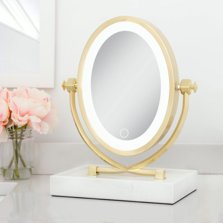 Zadro LOVGLAM55 705004424363 environment photo front right angle view, brooklyn led lighted makeup mirror with magnification & marble trayon top of a bathroom countertop & next to a bouquet of flowers