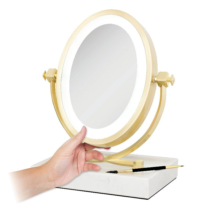 Zadro LOVGLAM55 705004424363 product photo front right angle view with items in tray and hand touching, brooklyn led lighted makeup mirror with magnification & marble tray in front of a white background