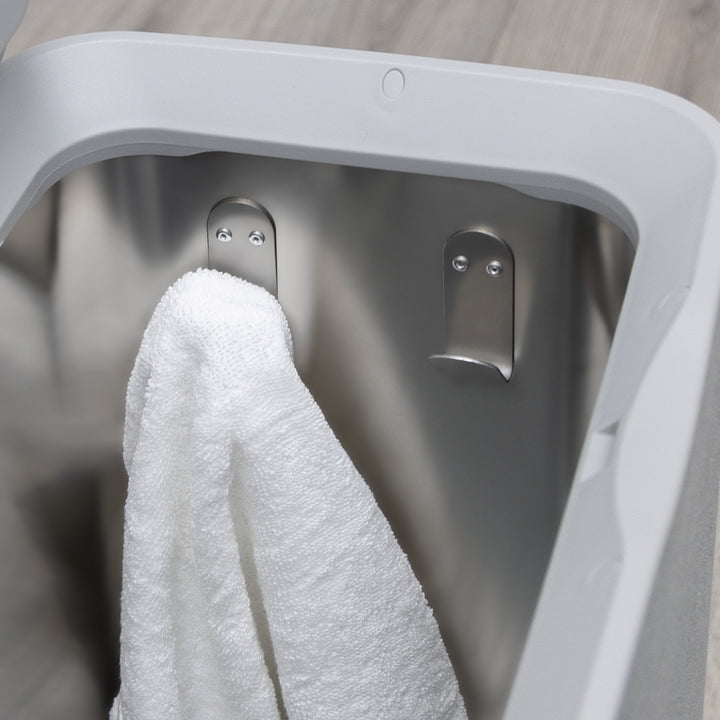 Gray towel warmers inside view showing a stainless steel tub without removable tray and with hooks and a hanging white towel over a gray wooden bathroom floor surface