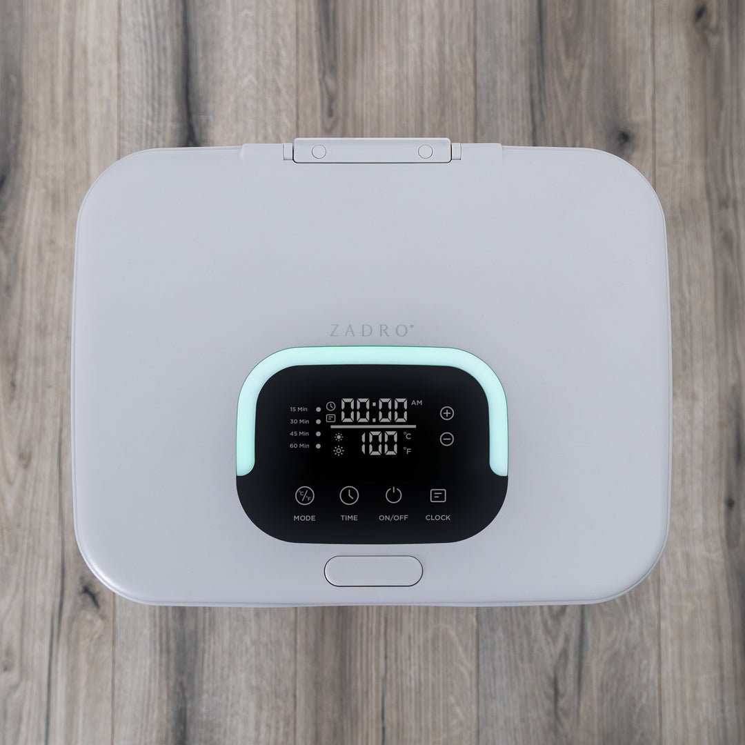 Gray towel warmer's electronic LED lighted digital display on a wooden bathroom floor surface