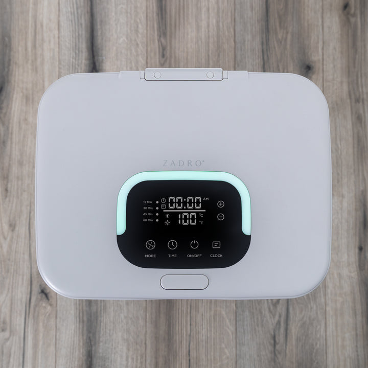 Gray towel warmer's electronic LED lighted digital display on a wooden bathroom floor surface