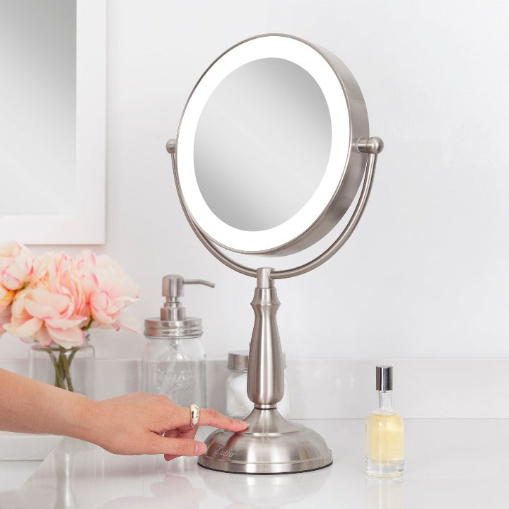 Zadro LEDVPRT410 705004420921 in-use photo side view hand touching base, lighted makeup mirror with magnification & touch base in a real life setting