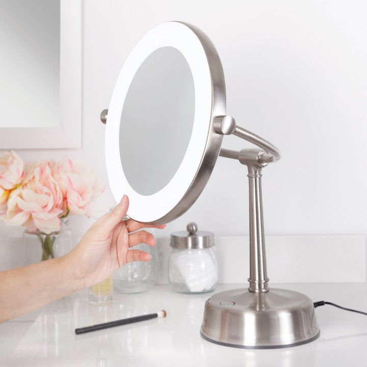 Zadro SLVRLT410 705004420686 in-use photo side view with hand adjusting height, lexington lighted makeup mirror with magnification in a real life setting