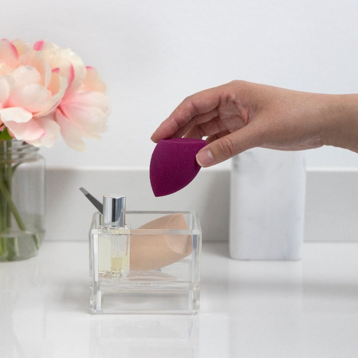 Zadro ZOR1 705004415279 environment photo in use hand placing makeup sponge, acrylic beauty makeup organizer - tray cube in front of a real life setting